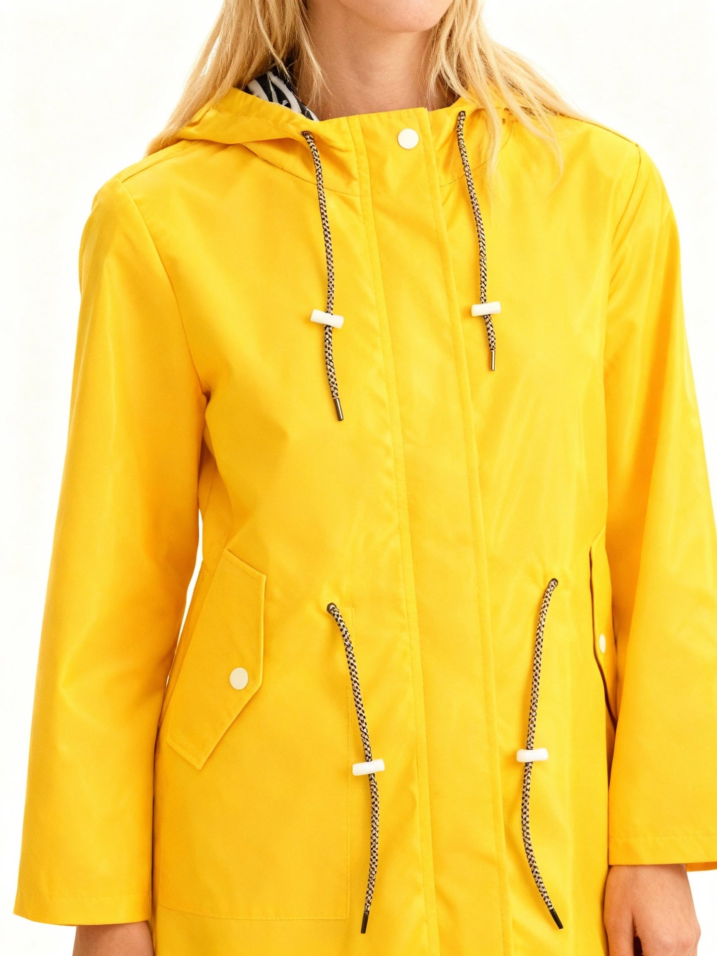 Yellow waterproof hooded coat close-up with drawstring ties, zip front, button flap pockets