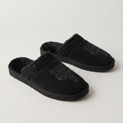 Pair of black slip-on cowboy slippers with faux-fur lining and curved stitch design