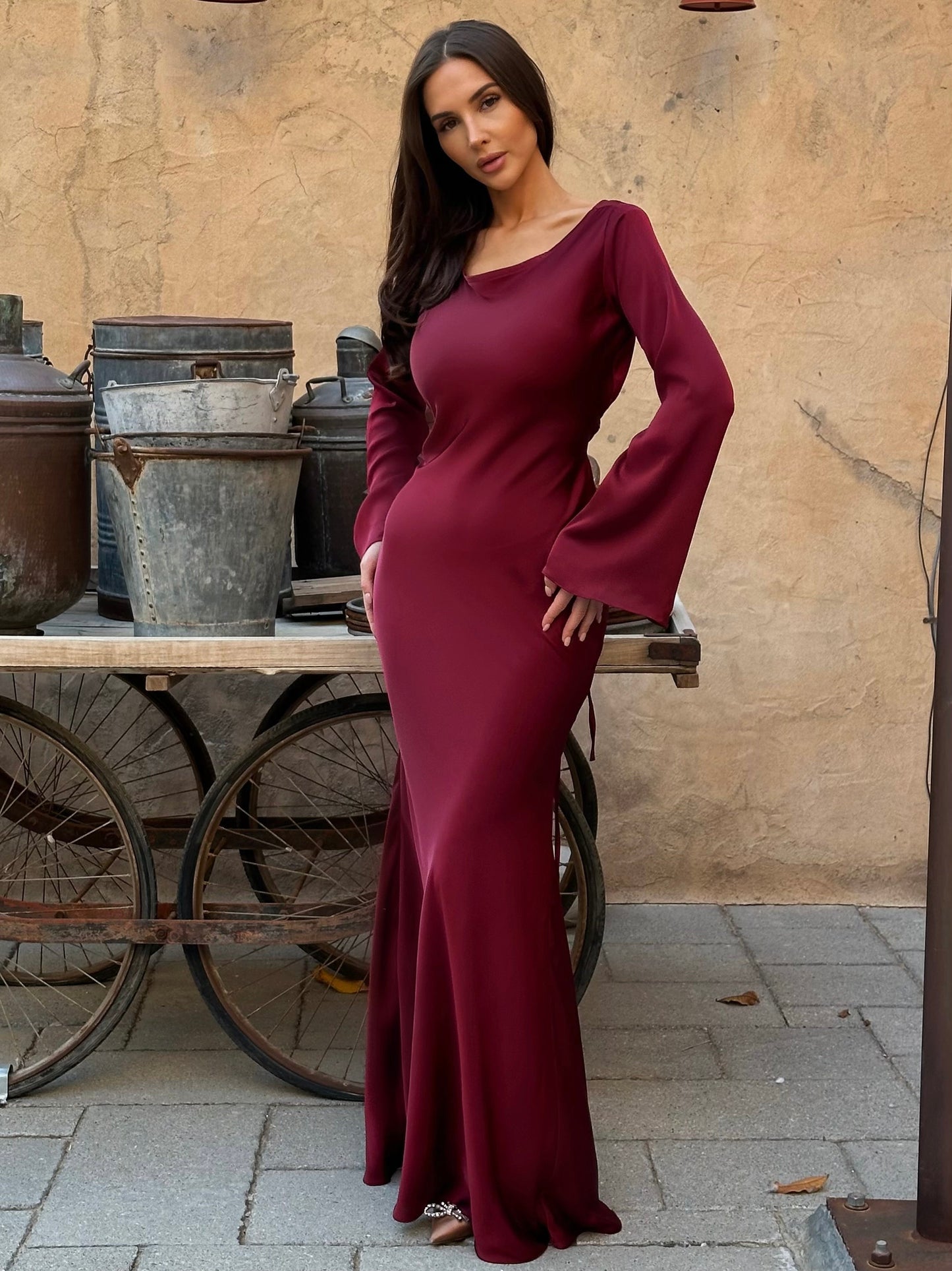 Burgundy long-sleeve fitted maxi dress with scoop neckline and flared sleeves