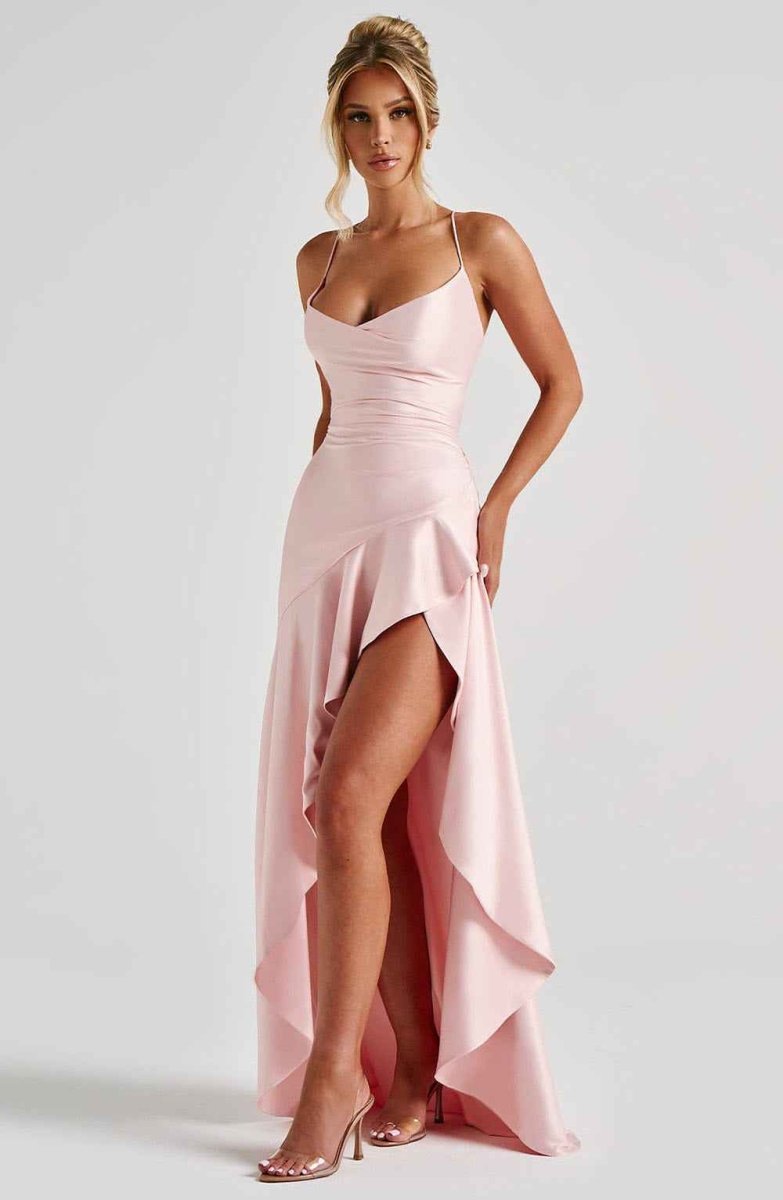 Light pink maxi dress with spaghetti straps, fitted bodice, and draped ruffle hem