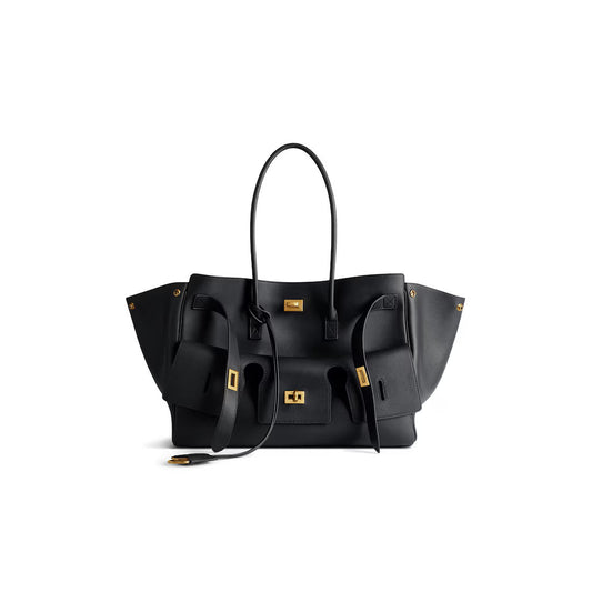 Black structured handbag with dual straps and gold-tone hardware, front logo panel