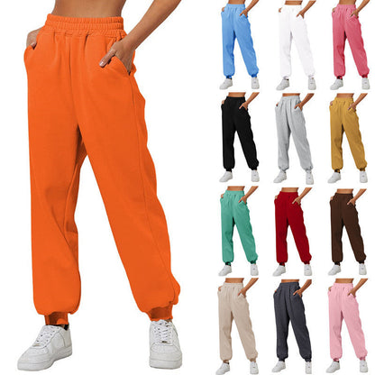 Orange sweatpants joggers with elastic waistband and tapered cuffed legs.