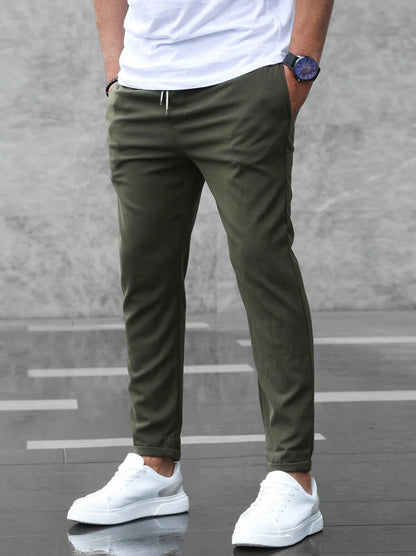Mens olive green drawstring jogger pants with tapered legs and ankle cuffs