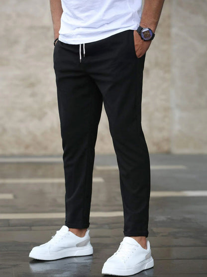 Mens black drawstring jogger pants with tapered fit and ankle cuffs