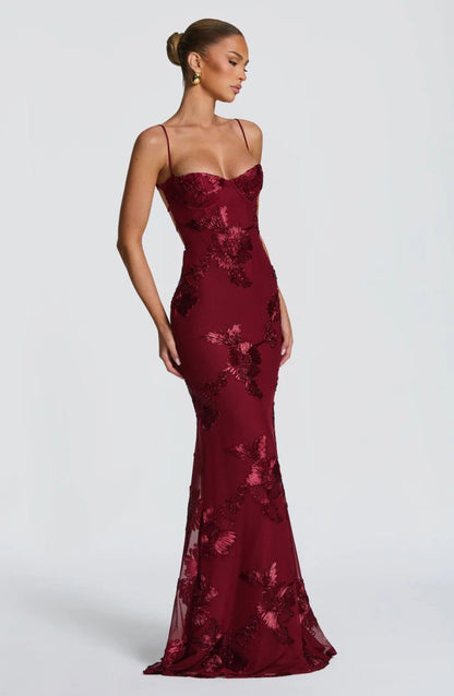 Red lace maxi dress with spaghetti straps and allover floral embroidery, fitted.
