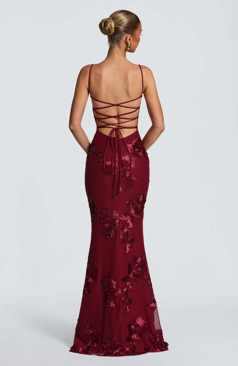 Red lace maxi dress with crisscross open back and lace-up ribbon detail.