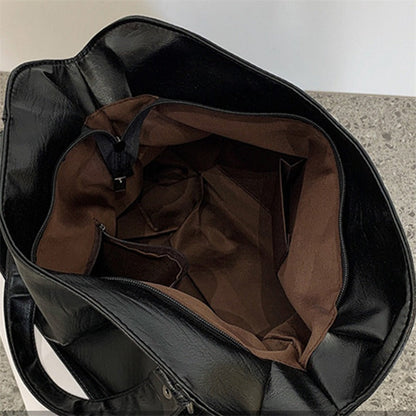 Black vegan leather handbag interior view with brown lining and inner zip pocket