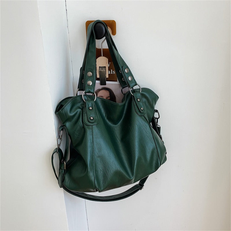 Green vegan leather handbag with two top handles and a detachable shoulder strap