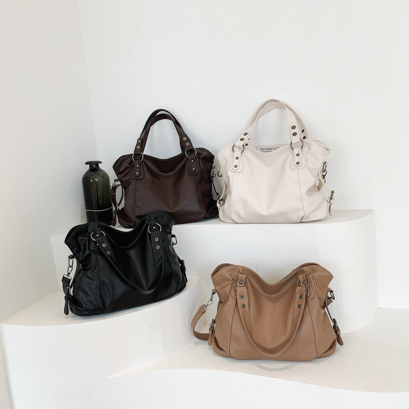 Vegan leather handbags in mixed colors: dark brown, black, white, and tan on a shelf