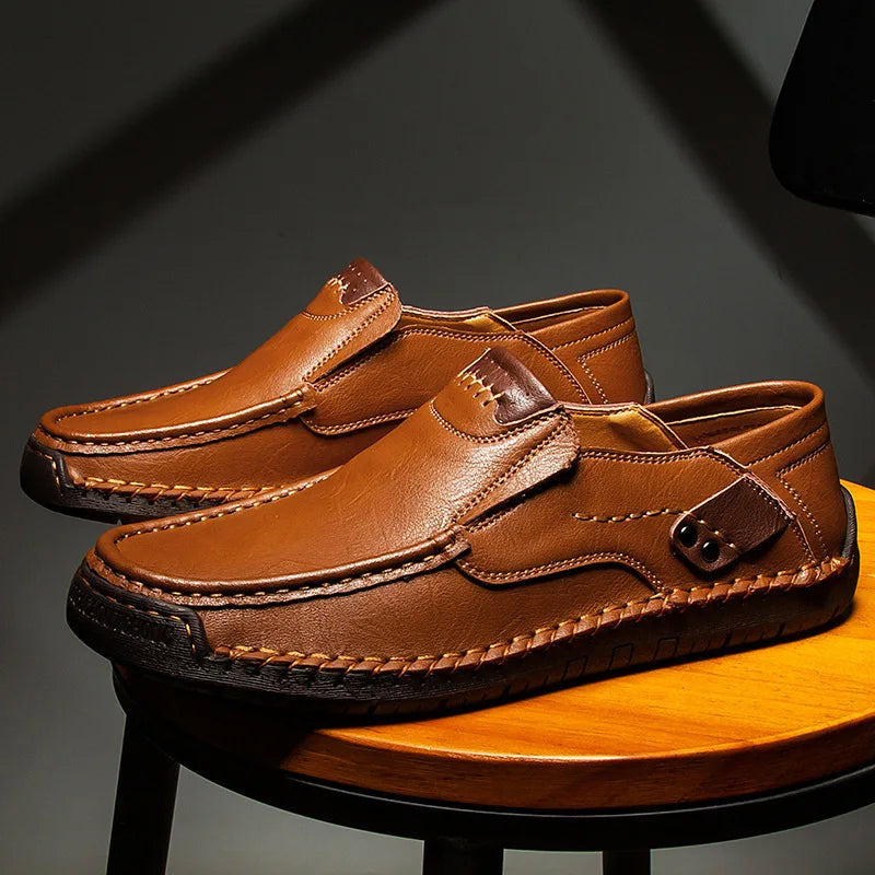 Men's light brown leather loafer with moc-toe stitching and strap with metal eyelet