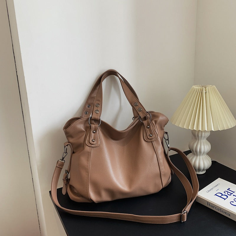 Light brown vegan leather handbag with front pocket and detachable crossbody strap