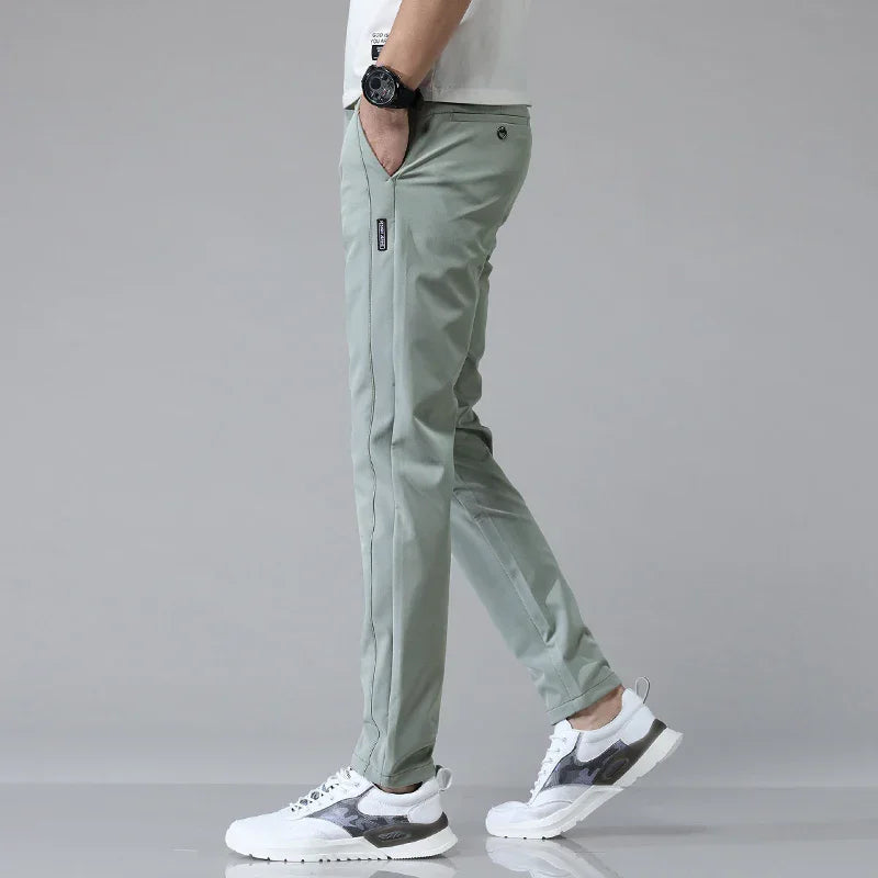 Slim-fit light green pants with tapered legs and side zip pocket