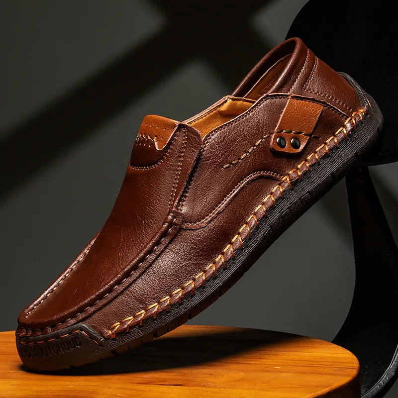 Men's dark brown leather loafer with moc-toe stitching and strap with metal eyelet