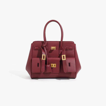 Maroon structured handbag with top handles and gold-tone hardware, front logo panel