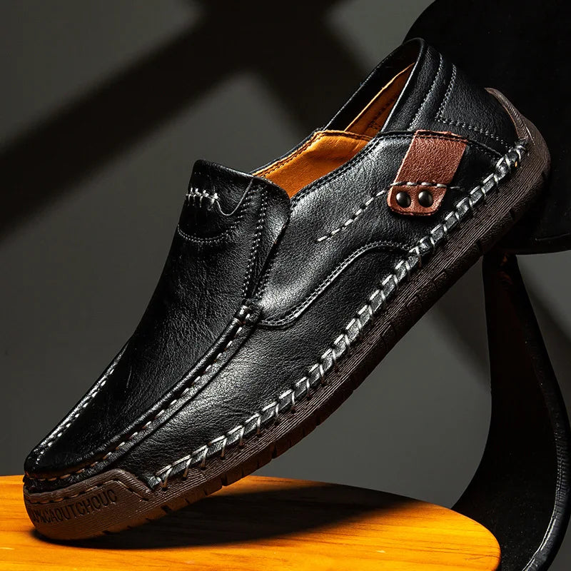 Men's black leather loafer with moc-toe stitching and strap with metal eyelet