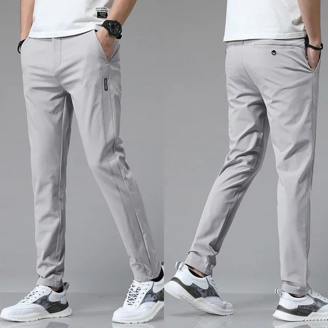 Slim-fit light gray pants with zip fly, button closure, and side pockets