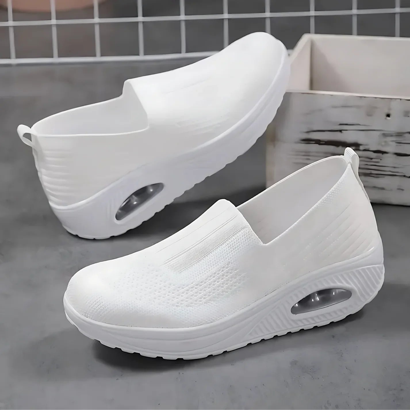 White knit slip-on walking shoe with cushioned sole and oval air-cushion window