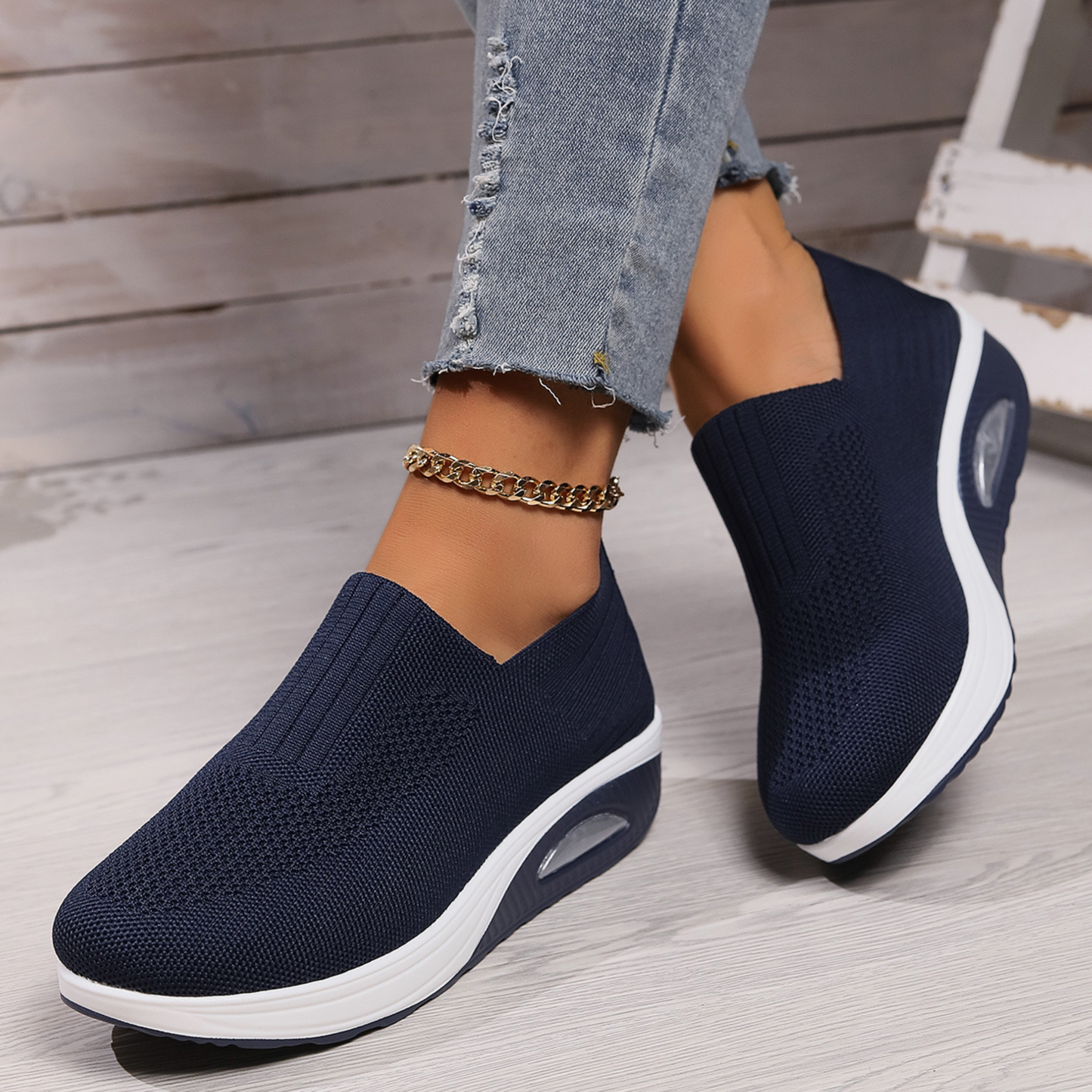 Dark blue knit slip-on walking shoe with cushioned sole and oval air-cushion window
