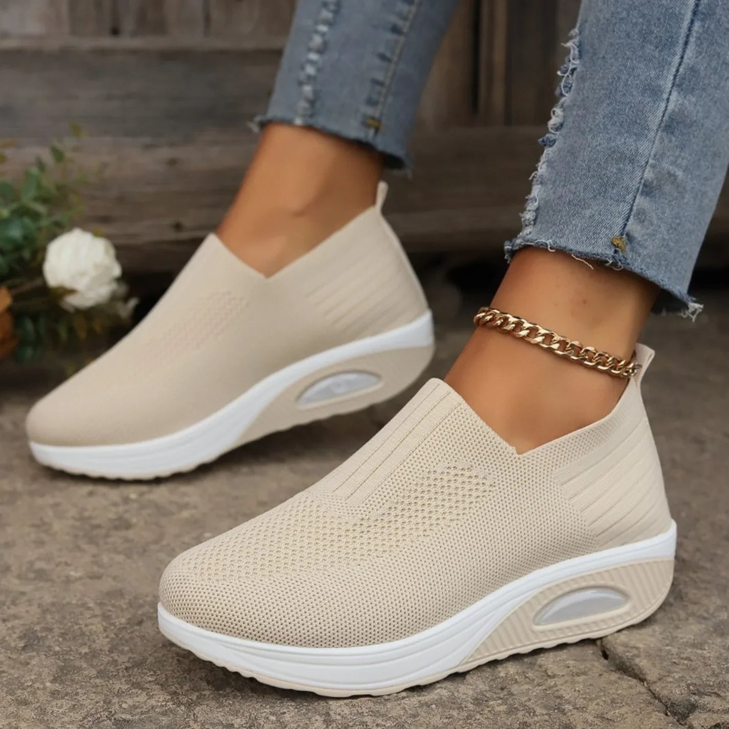 Beige knit slip-on walking shoes with cushioned sole and oval air-cushion window