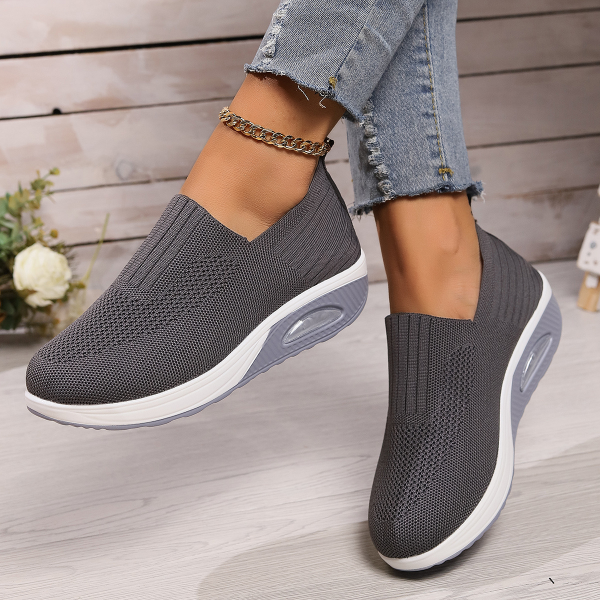 Grey knit slip-on walking shoes with cushioned sole and oval air-cushion window