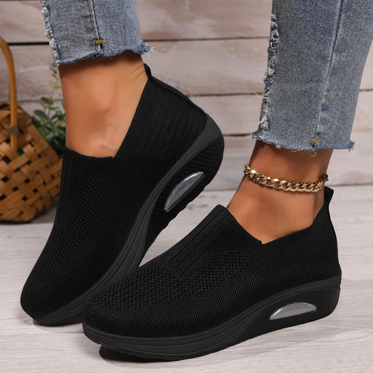 Black knit slip-on walking shoe with cushioned sole and oval air-cushion window