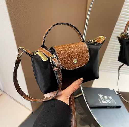 Mini leather pouch, black with brown front flap and gold snap, top handle and crossbody strap