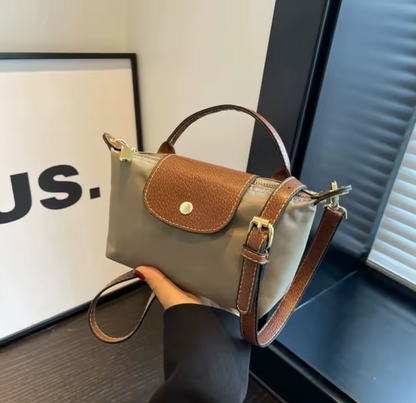 Mini leather pouch, tan with brown front flap and gold snap, top handle and crossbody strap