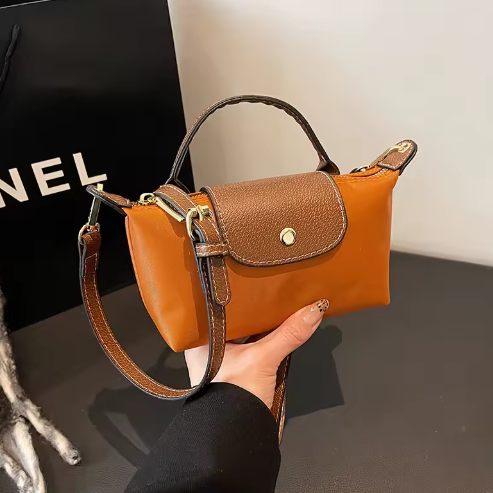 Mini leather pouch, orange with brown front flap and gold snap, top handle and shoulder strap