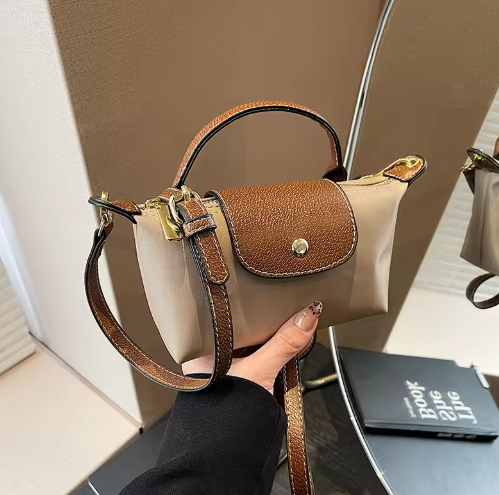 Mini leather pouch with flap, top handle, gold-tone hardware, adjustable strap