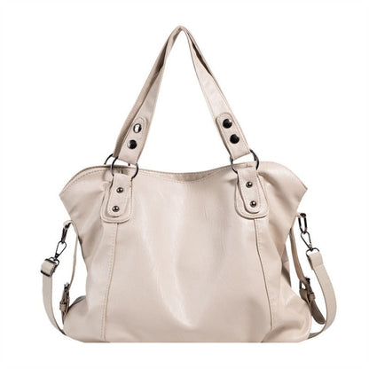 Beige vegan leather handbag with two top handles and silver-tone strap hardware