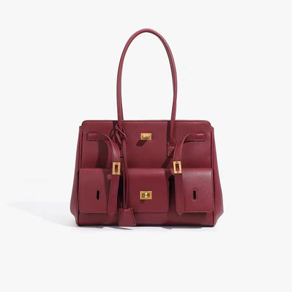 Maroon structured handbag with side pockets and gold-tone hardware, angled view