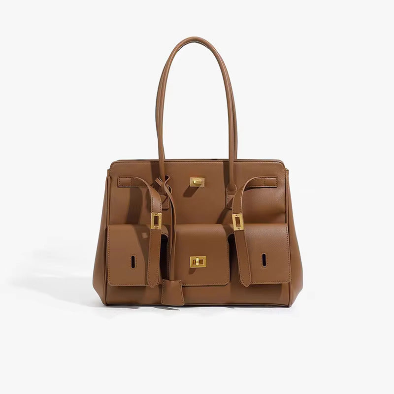 Brown structured handbag with side compartments and gold-tone hardware, three-quarter view