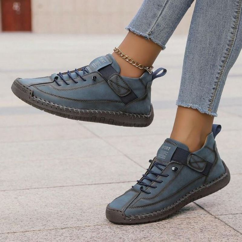 Denim blue slip-on trainers with lace-up front and ankle strap, thick rubber sole