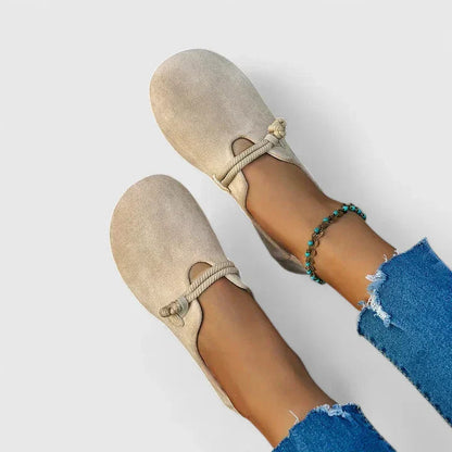 Beige slip-on walking shoes with knotted elastic strap and rounded toe, side view