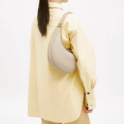 Off-white convertible handbag worn crossbody with adjustable strap