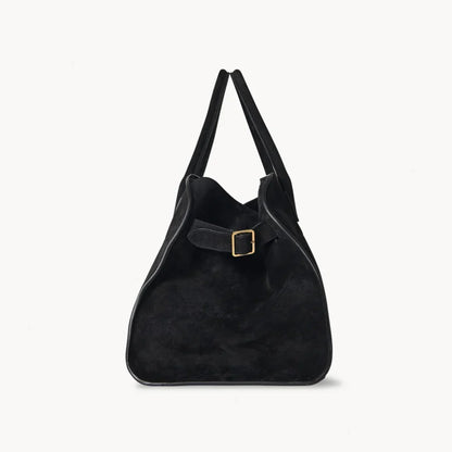 Black suede shoulder tote with open top, two straps, and square gold buckle patch