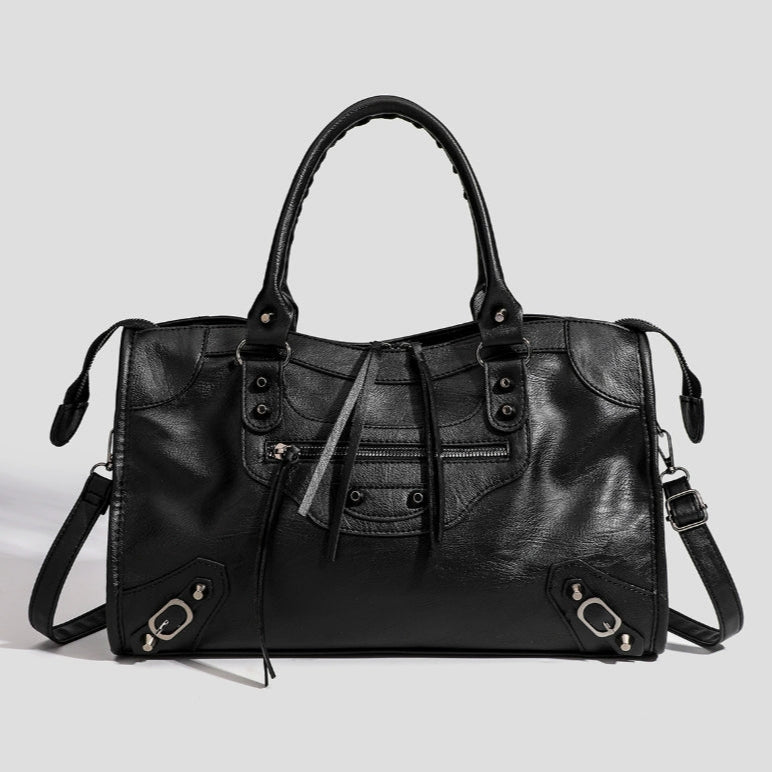 Black vegan leather tote bag with top handles, front pockets, and adjustable strap