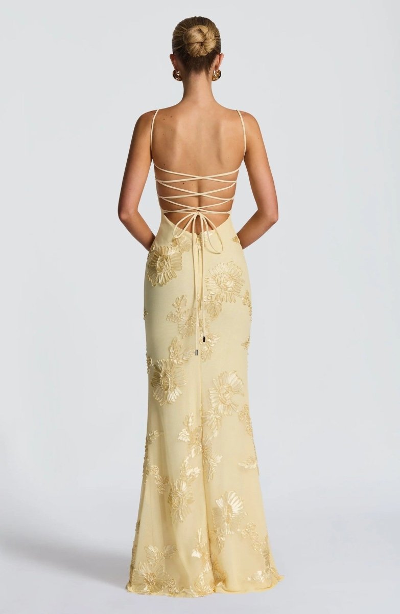 Light yellow lace maxi dress with open back crisscross straps and tie detail.