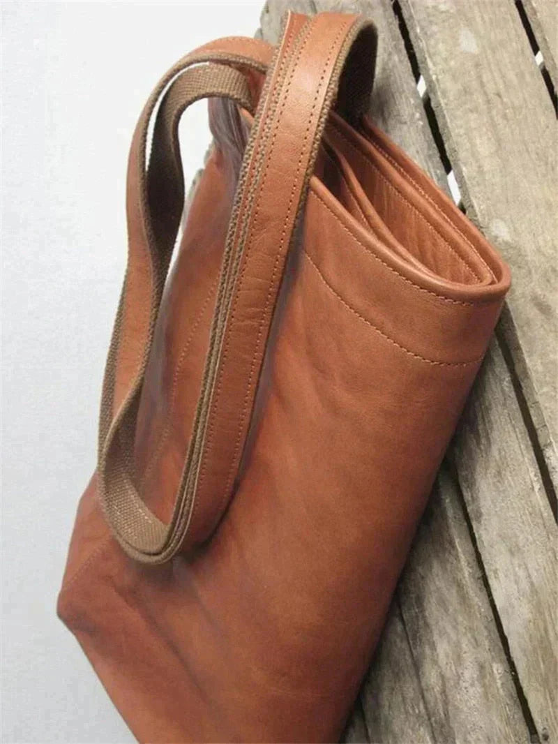 Brown leather tote bag with double top handles and reinforced stitching