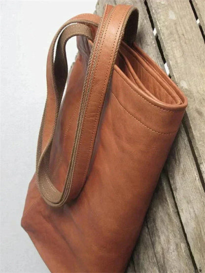 Brown leather tote bag with double top handles and reinforced stitching