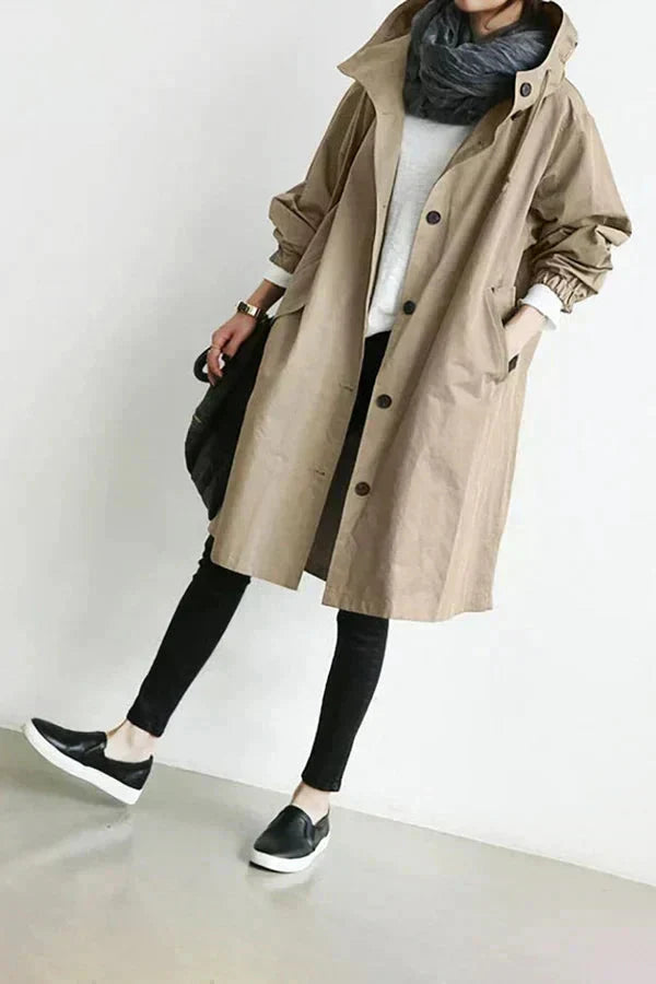 Women’s raincoat in beige with oversized hood and button-front, long sleeves.