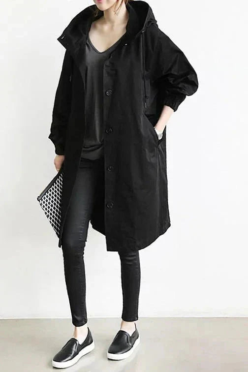 Women’s raincoat in black with oversized hood and button-front, long coat length.