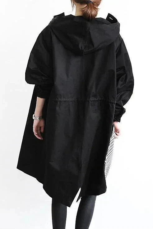Women’s raincoat in black with oversized hood and back yoke seam, long sleeves.