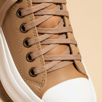 Beige platform sneaker close-up: lace-up loops and white midsole edge detail