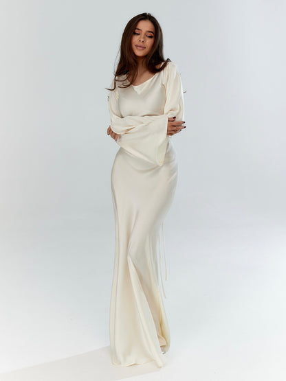 Long-sleeved maxi dress in off-white with fitted bodice and draped skirt
