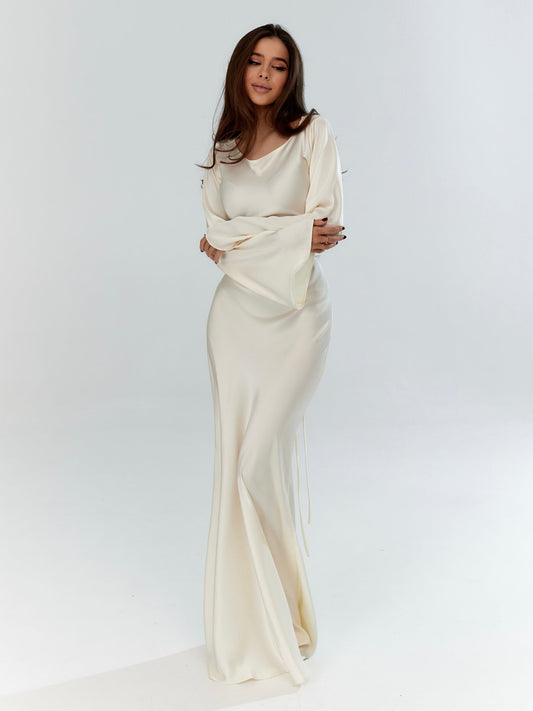 Long-sleeved maxi dress in off-white with fitted bodice and draped skirt