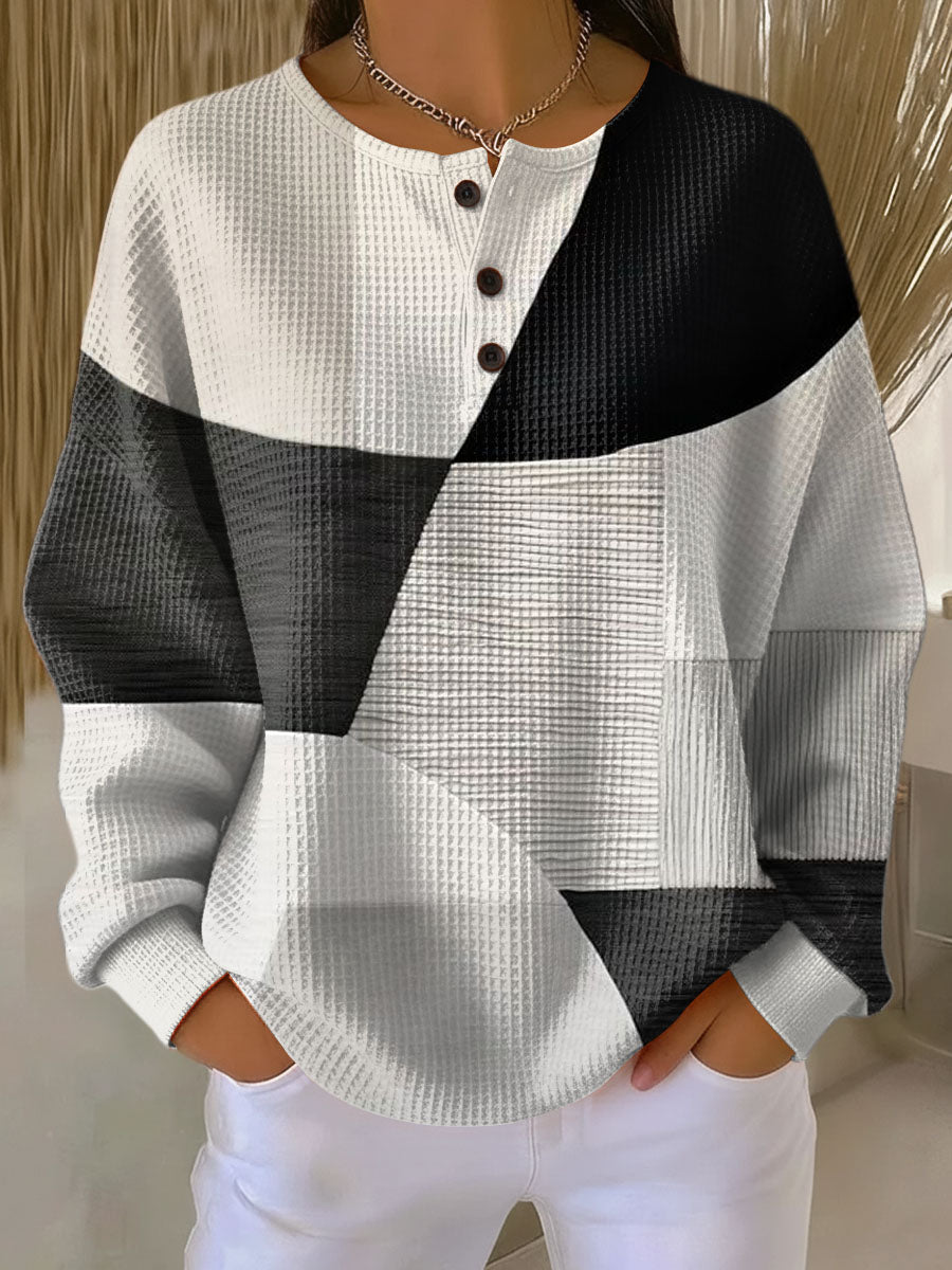 Black-and-cream waffle-knit henley jumper with diagonal color-block panels and black buttons