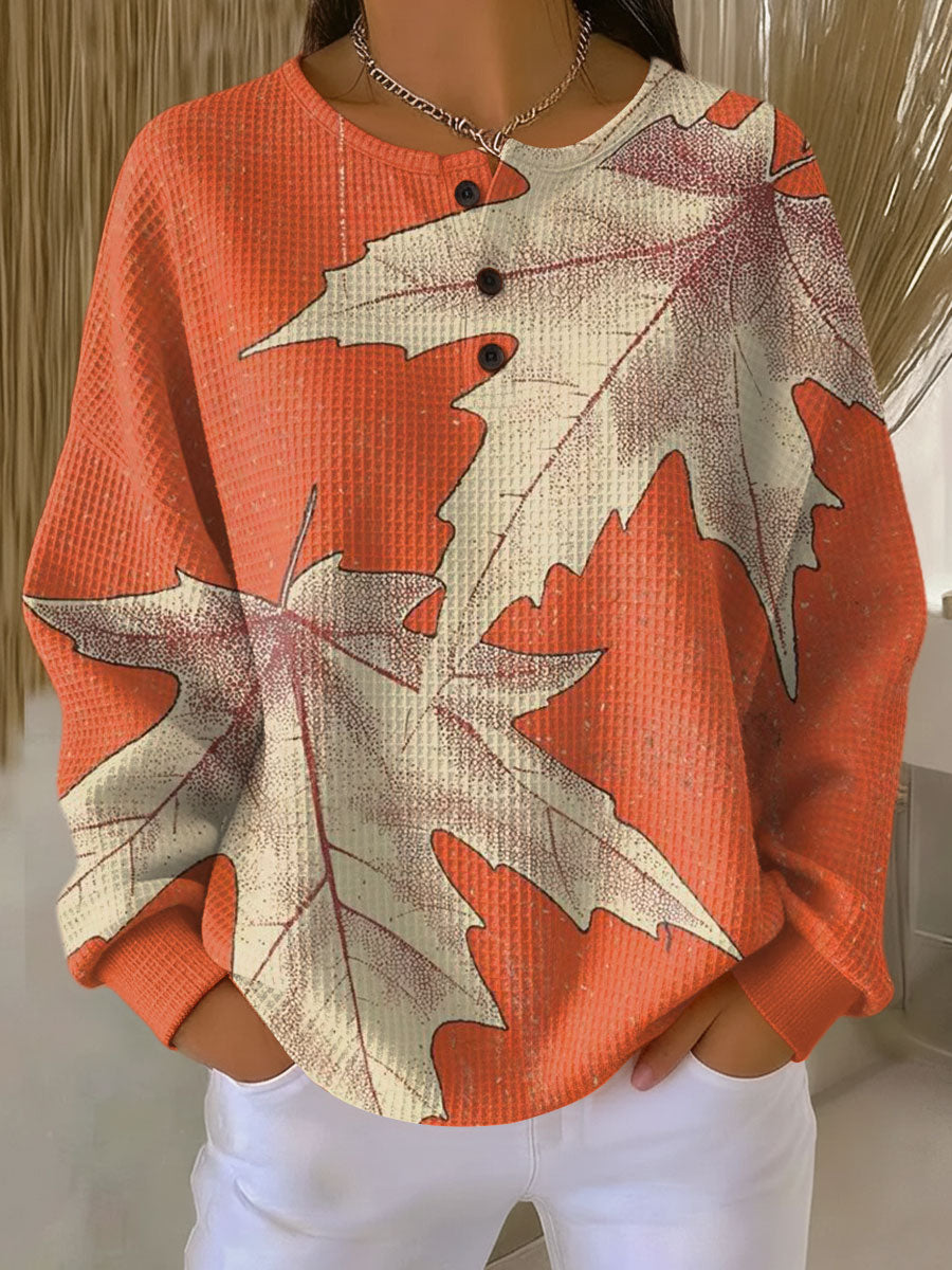 Women's waffle-knit jumper in rust orange with large leaf graphic print