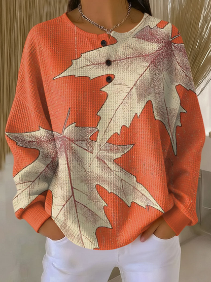 Women's waffle-knit jumper in rust orange with large leaf graphic print