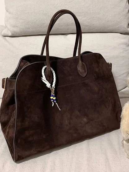 Brown suede tote handbag with two top handles and beaded keychain charm